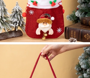 Close-up of red burlap Christmas candy bag with Santa applique and golden bell detail