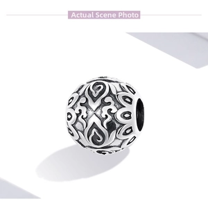 Macro detail of retro engraved silver bead with intricate floral patterns for DIY bracelets