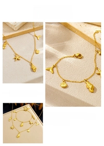 Detailed view of gold ocean charms with seahorse and starfish on stainless steel set
