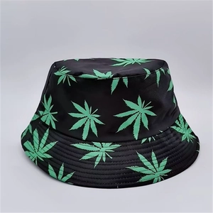 Detail of reversible fisherman hat with green leaf print on black fabric texture