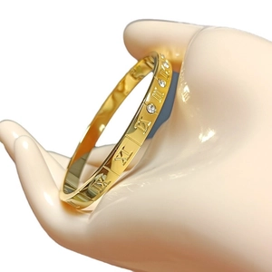 Elegant gold-plated stainless steel bangle with Roman numerals and diamond accents