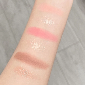 Arm swatches of 18-color eyeshadow palette showing matte and shimmer textures