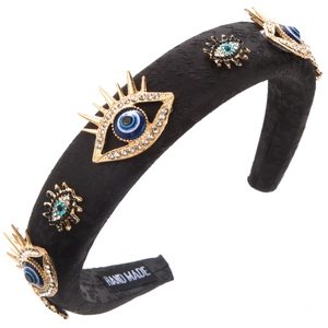Dettaglio del cerchietto in jacquard nero con ciondoli evil eye in cristallo e etichetta fatta a mano