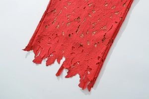 Close-up of red lace dress with intricate floral hollow embroidery and scalloped edges