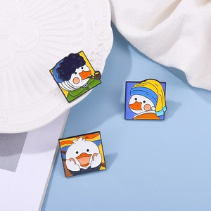 Three enamel pins with cartoon duck versions of famous oil paintings on blue background