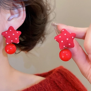 Macro shot of red polka dot star fabric earrings with glossy spherical pendant detail