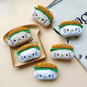 Detail of cute plush Hello Kitty burger hair accessories and brooches on a ceramic plate