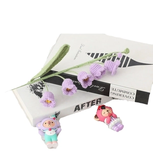 Handmade crochet Lily of the Valley purple knitted flowers bouquet on vintage books
