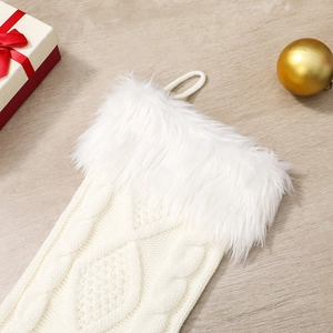 Détail d'une chaussette de Noël en tricot torsadé blanc avec bordure en peluche douce