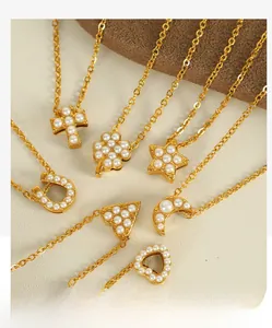 Détail de plusieurs colliers dorés avec pendentifs en trèfle et croix ornés de perles