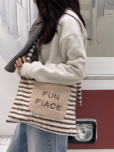 Winter fuzzy tote bag with striped pattern and plush pocket featuring embroidery detail