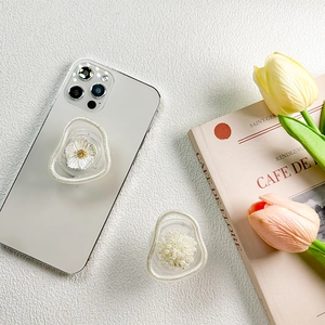 Korean style pearl and flower phone griptok holder with glitter wave border on white table