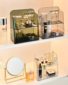 Close-up of tiered acrylic organizer with jewelry hooks and cosmetic storage compartments