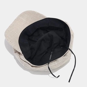 Flat lay of retro octagonal baker boy hat showing light brown plaid and inner lining