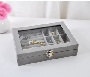 Macro view of velvet jewelry box with glass window showing ring slots and metal clasp
