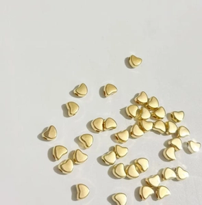 Gros plan de perles d'espacement CCB dorées en forme de cœur pour bijoux DIY