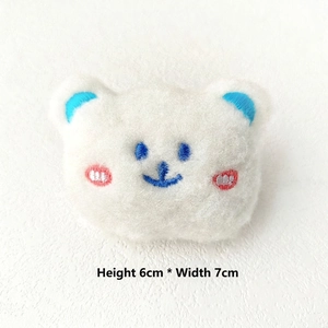 Close-up of white plush bear brooch with blue embroidery, 6cm x 7cm detail view