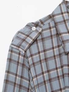 Detail of blue and brown plaid shirt dress showing shoulder epaulet and white buttons