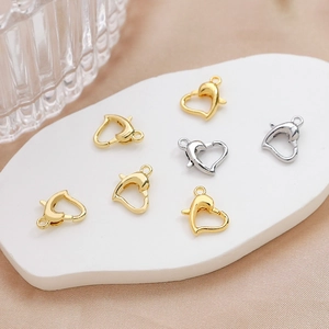 Detail shot of heart-shaped gold and silver lobster clasps for DIY jewelry making