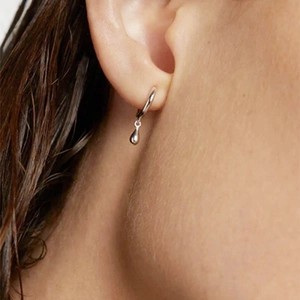 Macro shot of silver drop earrings on model showcasing elegant minimalist metal design