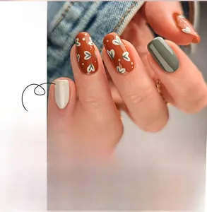 Detail of JP2879 press-on nails featuring caramel orange and floral heart patterns