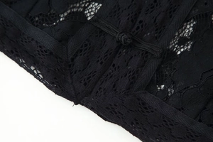 Gros plan sur la texture en dentelle noire avec détail de bouton noeud de la blouse