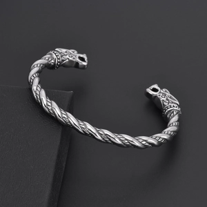 Detailopname van een vintage zilveren drakenkop armband met een gedraaid koordontwerp.