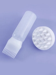 Detail of 6oz hair oil bottle with applicator and silicone scalp massage brush set