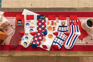 Detail of six cotton festive crew socks with red holiday patterns and auspicious phrases