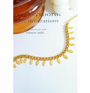 Detailed macro view of 18k gold plated chain bracelet with hanging oval leaf charms