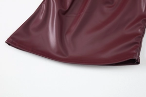 Detailed macro view of dark burgundy PU leather skirt texture and high-quality stitching