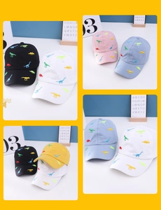 Close-up of high-quality colorful dinosaur embroidery on a selection of cotton baseball caps