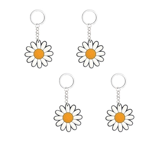 Set of four white daisy PVC keychains with yellow centers and silver metal rings