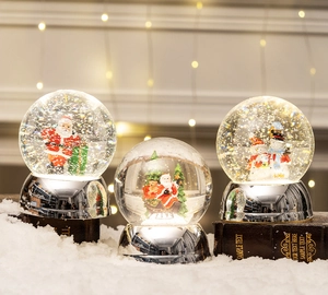 Detailed view of Christmas crystal balls with Santa and snowman on a silver base