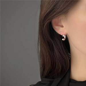 Close-up of minimalist 925 sterling silver U-shaped hoop earring on model ear lobe