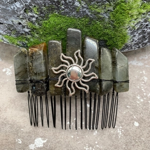 Close-up of handmade labradorite crystal hair comb with a silver sun motif and metal wire wrap