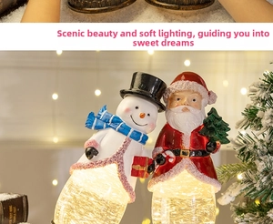 Close-up of glowing Christmas water globe featuring Santa and Snowman in a warm bokeh scene