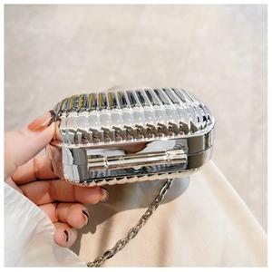 Detail view of mini silver suitcase bag with metal chain and vertical stripe texture