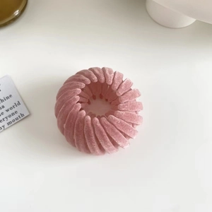 Detailed view of a pink velvet nest-shaped hair claw clip with a soft flocked texture