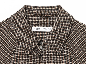 Close-up of houndstooth tweed jacket collar with brand size tag and fabric texture