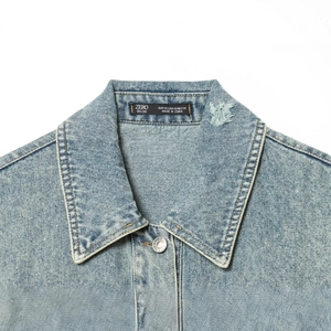 Oversized light blue denim jacket with vintage distressed details and metal buttons