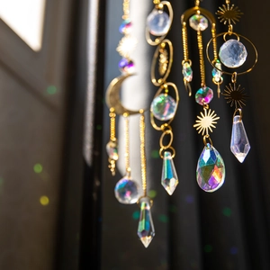 Brass suncatcher with crystal prisms hanging in sunlight showing colorful light refraction