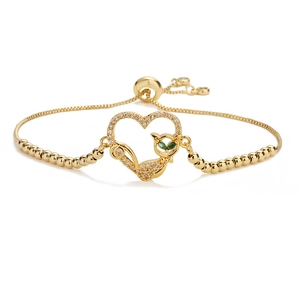 Détail du bracelet cœur en or 18K avec silhouette de chat et yeux en pierre verte