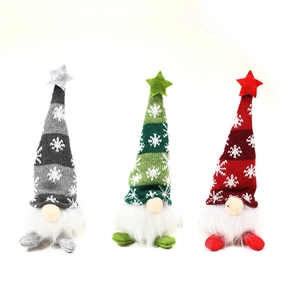 Detailed close-up of a three-piece set of knit Christmas gnomes in red, green and grey