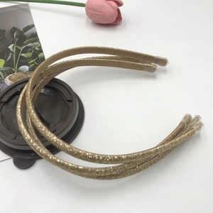 Detailed view of three gold glitter headbands with protective caps on a stylish background