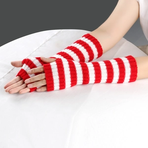 Detail of red and white striped knitted long fingerless gloves worn on arms