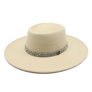 Close-up of beige wool fedora with diamond band and gold M badge detail