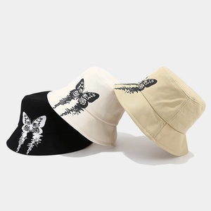 Three trendy bucket hats in black, white, and beige featuring butterfly graphic prints