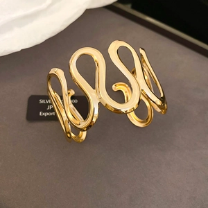 Detailed macro view of 925 silver wavy gold cuff bracelet with a modern hollow design