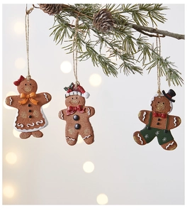Detailed view of gingerbread man ornaments with frosting texture hanging on a pine branch